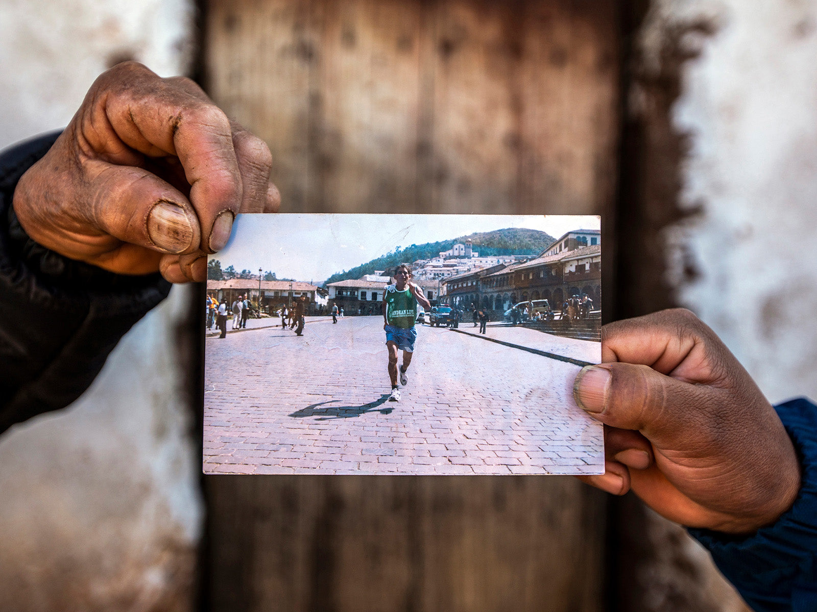 Saturnino Ayma and his son Kenedy hold a photo from when Saturnino was better known as “El Chasqui.” Plaza de Armas, Cusco, Peru.
