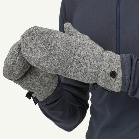 Grey heathered fleece mittens worn on hands, showing snap-button cuff closure and Patagonia logo tab